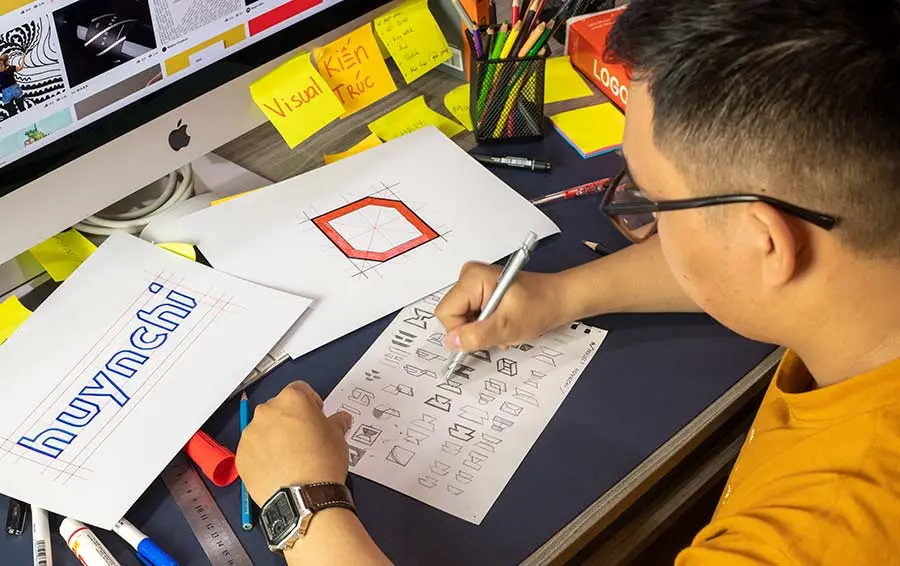 Hoạ sĩ thiết kế logo tại Vũ Digital đang phác thảo những ý tưởng trên giấy.