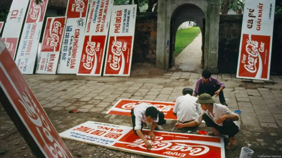 Các công nhân vẽ bảng quảng cáo Coca Cola năm 1994 (ảnh: BBC)